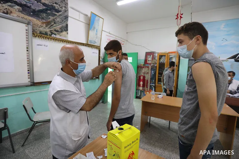 Palestinian students get inoculated with a dose of the Covishield vaccine against the Covid-19 coronavirus, at a school, in Nuseirat refugee camp in central Gaza Strip, on September 1, 2021. Palestinian health authoritie...