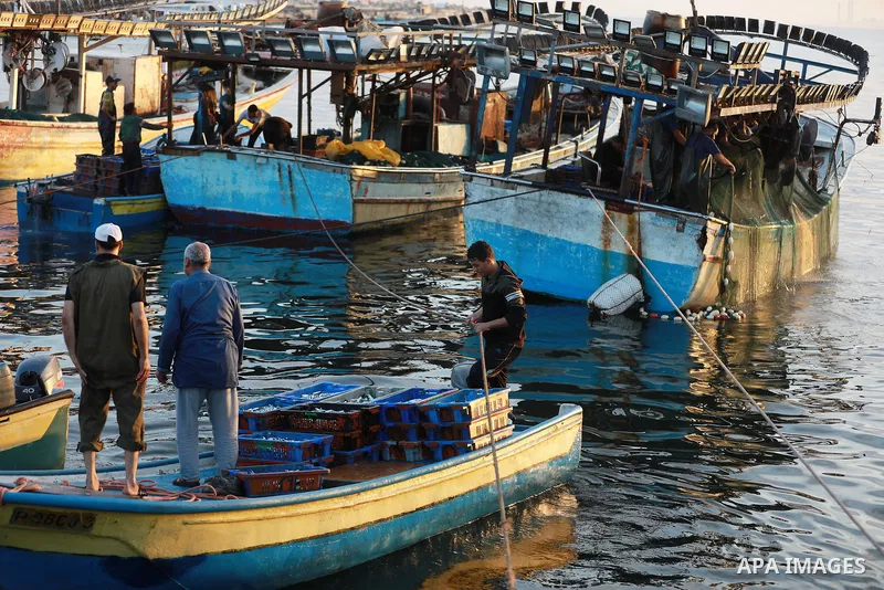 Palestinian fishermen work on their boats after Israel expand the fishing zone in the Gaza Strip to 15 nautical miles, in Gaza city on September 2, 2021. Israel said it would expand Gaza's fishing zone, increase its wate...