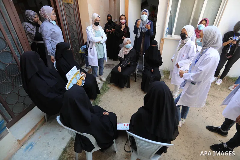 Palestinian medicals and activists participate during the "Awareness Bus" initiative to educate people about the Corona vaccine in poor areas, in Beit Lahia in the northern of Gaza Strip on September 2, 2021. Photo by As...