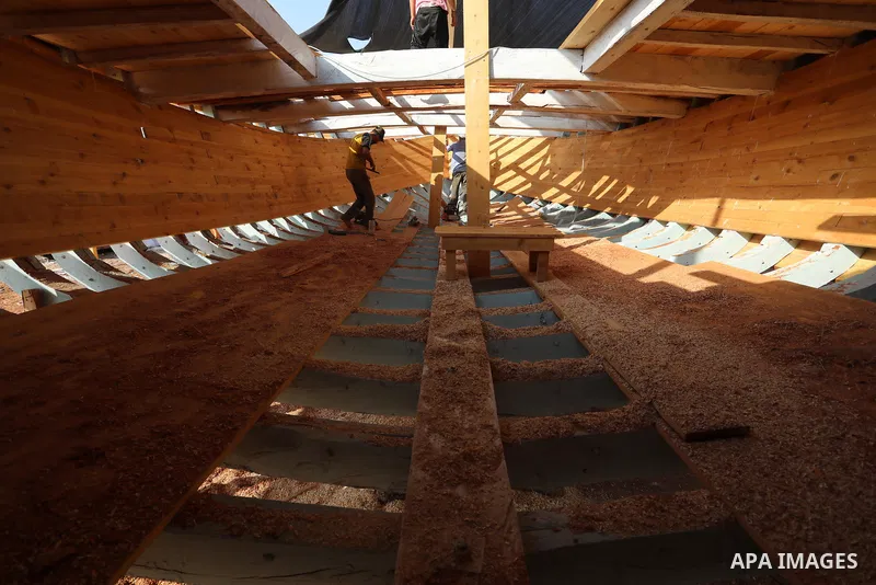Palestinians work on the largest fishing boat in Khan Yunis in the southern of Gaza Strip, on September 5, 2021. Palestinians made the largest fishing boat in the Gaza Strip, 21 meters long and 6 meters wide, with simple...