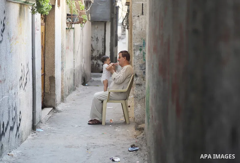 A Palestinian man plays with his grandson at a street in al- Shati refugee camp, west of Gaza City, on September 5, 2021. Over the last 14 years, Gaza residents have endured four deadly Israeli attacks, rebuilding after...