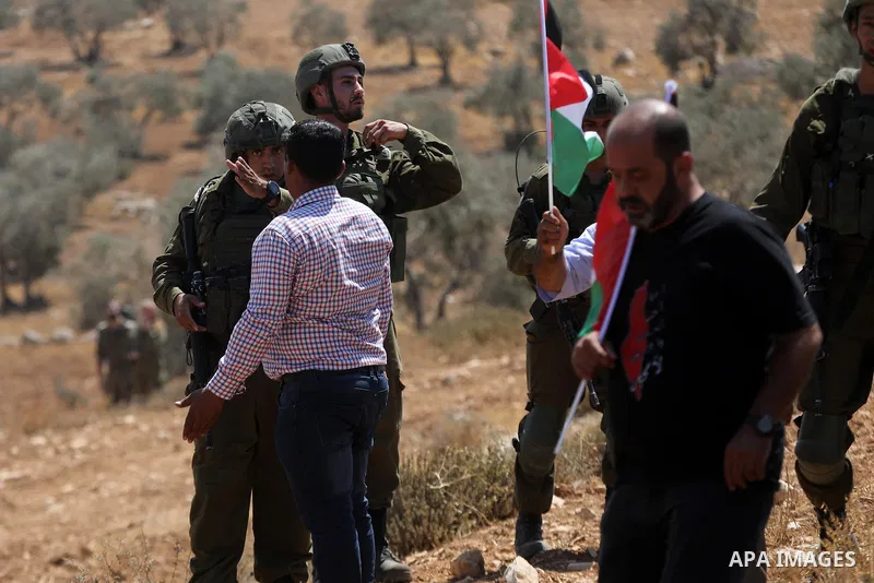 Protesters confront Israeli soldiers during a demonstration by Palestinian land-owners against confiscation of lands by Israel near the settlement of Ma'aon, by the Palestinian village of Yatta south of Hebron in the occ...