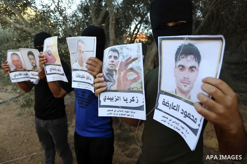 Masked Palestinians prepare balloons with photos of six prisoners who were escaped from an Israeli jail, to be flown towards Israel, along the Israel-Gaza border fence, east of Khan Younis in the southern Gaza strip on S...