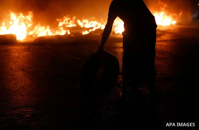 Palestinian demonstrators burn tires during confrontations with Israeli security forces following a rally in support of Palestinian prisoners held in Israeli jails, at the Hawara checkpoint near the West Bank town of Nab...
