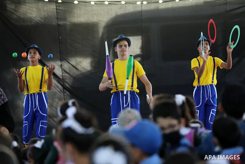 Palestinian students enjoy a circus performance, in Deir al-Balah in the center of Gaza Strip, on September 12, 2021. Members of Gaza stars circus school launched an initiative to entertain Palestinian children in margin...
