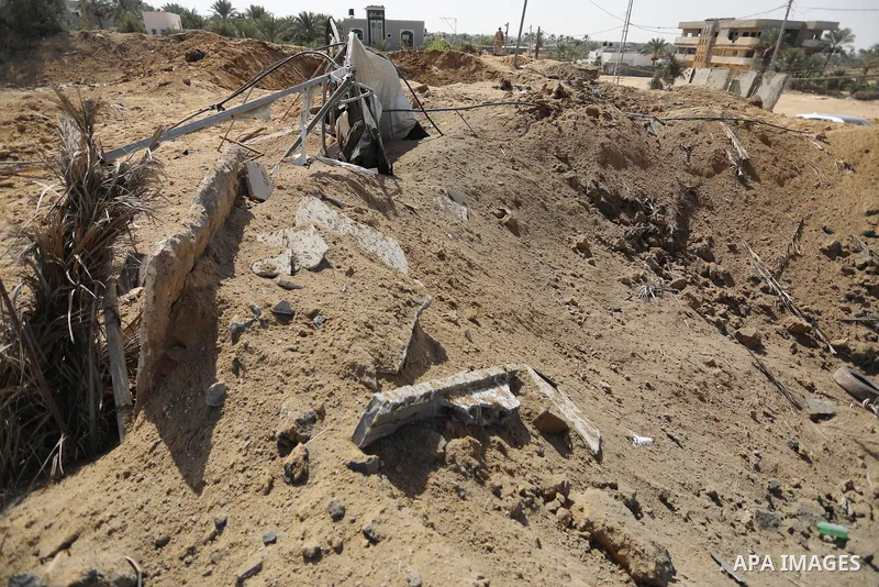 Palestinians inspect the site of an Israeli airstrike following the Palestinian rocket fire into Israel, in Deir al-Balah city in the central Gaza Strip, on September 13, 2021. For the third night in a row, Israeli warpl...