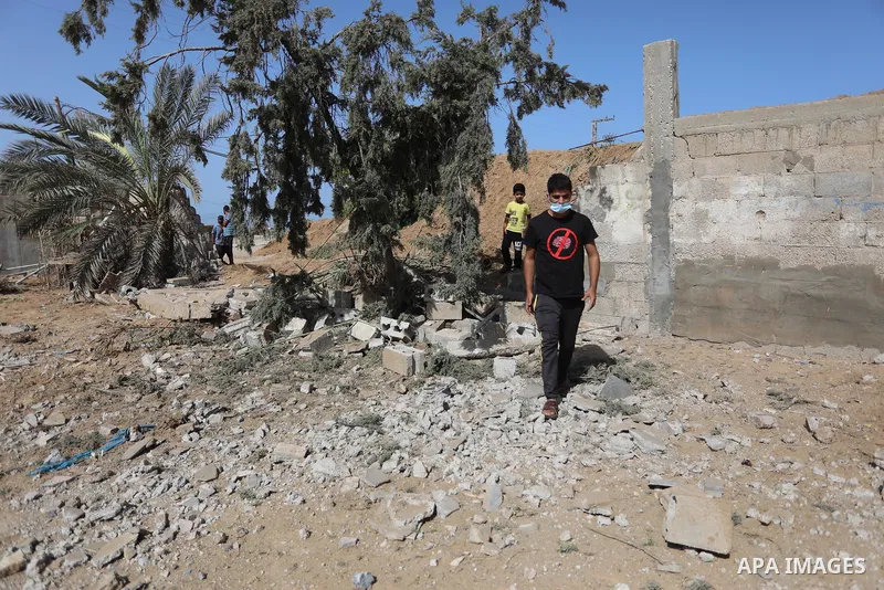 Palestinians inspect the site of an Israeli airstrike following the Palestinian rocket fire into Israel, in Deir al-Balah city in the central Gaza Strip, on September 13, 2021. For the third night in a row, Israeli warpl...