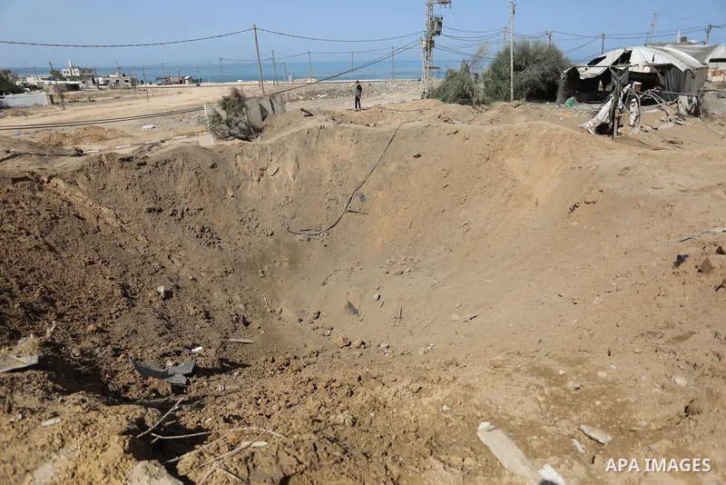 Palestinians inspect the site of an Israeli airstrike following the Palestinian rocket fire into Israel, in Deir al-Balah city in the central Gaza Strip, on September 13, 2021. For the third night in a row, Israeli warpl...