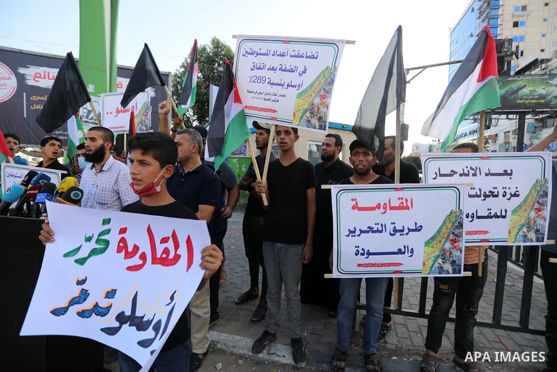 Palestinians hold placadrs during a rally on the occasion of the 28th anniversary of the Oslo accords between Palestinians and Israel, in Gaza city on September 13, 2021. In 1993, Israeli Prime Minister Yitzhak Rabin and...
