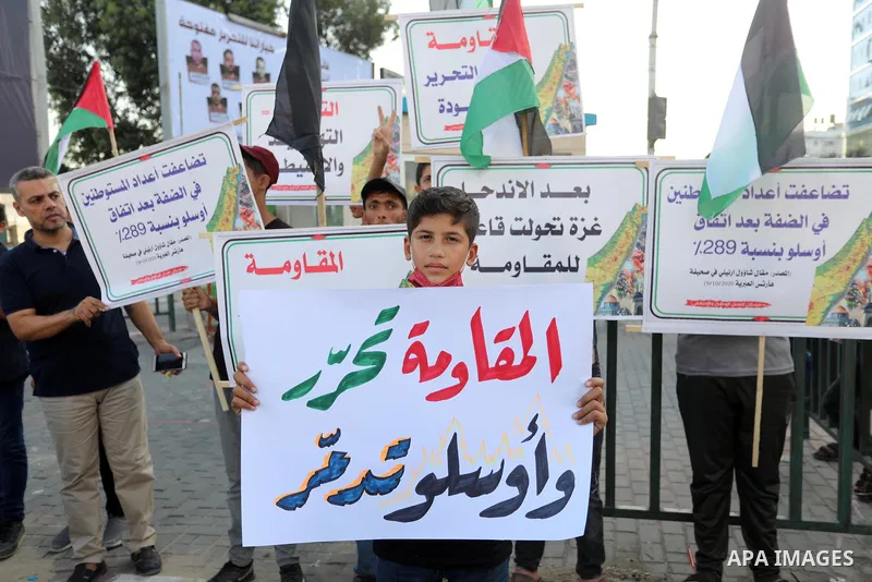 Palestinians hold placadrs during a rally on the occasion of the 28th anniversary of the Oslo accords between Palestinians and Israel, in Gaza city on September 13, 2021. In 1993, Israeli Prime Minister Yitzhak Rabin and...