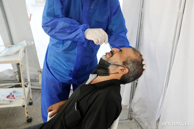 A Palestinian health worker collects a swab sample from a person for Covid-19 test, at a temporary vaccination centre set up, in Deir al-Balah in the center of Gaza Strip on September 15, 2021. COVID-19 claimed the life...