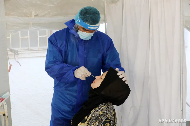 A Palestinian health worker collects a swab sample from a person for Covid-19 test, at a temporary vaccination centre set up, in Deir al-Balah in the center of Gaza Strip on September 15, 2021. COVID-19 claimed the life...