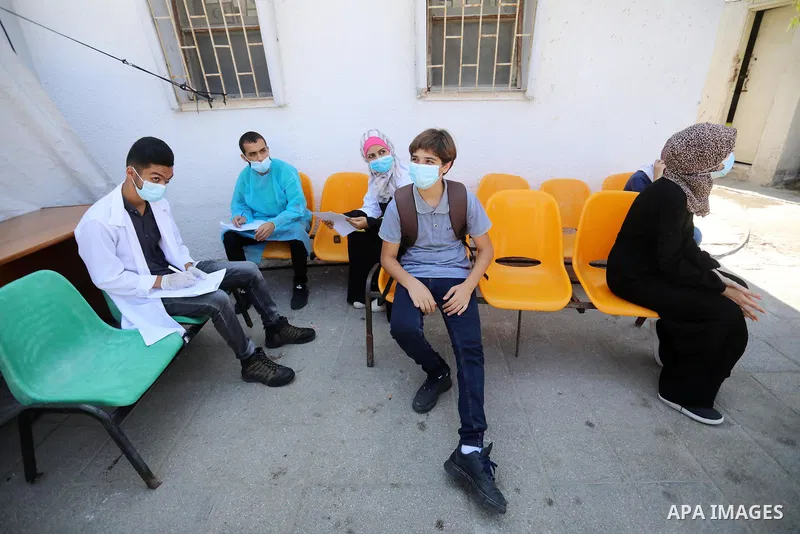 A Palestinian health worker collects a swab sample from a person for Covid-19 test, at a temporary vaccination centre set up, in Deir al-Balah in the center of Gaza Strip on September 15, 2021. COVID-19 claimed the life...