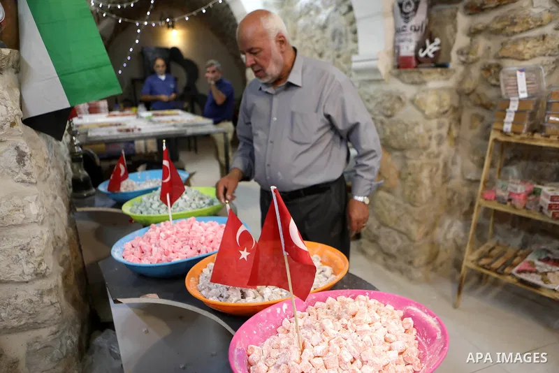 A Palestinian man sells Turkish delight sweets or holkum at a sweet shop in the Old City in West Bank city of Hebron, on September 20, 2021. Turkish delight or lokum is a family of confections based on a gel of starch an...