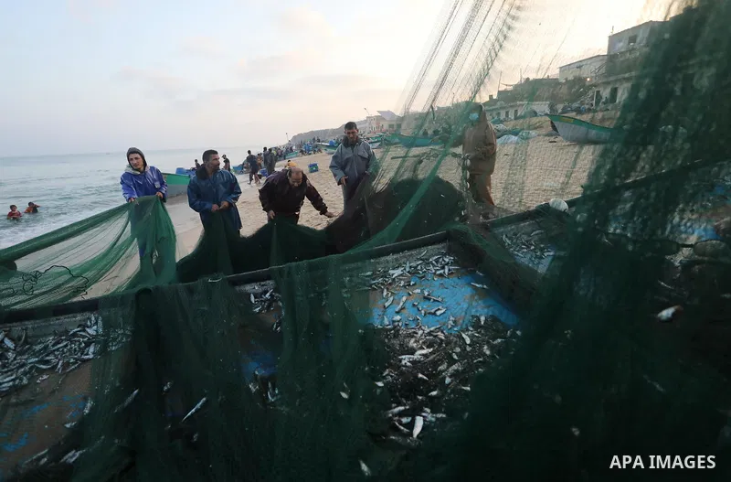 Palestinian fishermen work on the shore of the Mediterranean Sea, in Deir El-Balah, in the center of Gaza strip, on September 21, 2021. Fishing is a major source of revenue for the impoverished Palestinian enclave. Israe...