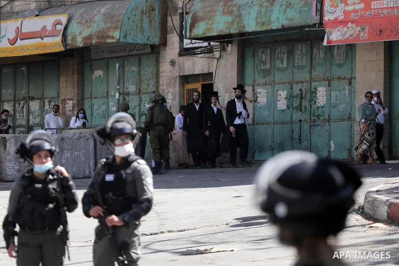 Israeli forces stand guard as groups of Israeli Ultra Orthodox Jews on their way to visit the tomb of Othniel Ben Kenaz in an Arab neighbourhood of the divided West Bank city of Hebron on September 22, 2021. Photo by Mam...