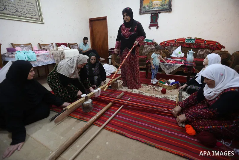 Palestinian women weave the traditional products, wool ornaments and carpets in the West Bank city of Hebron on September 23, 2021. Weaving sheep's wool into traditional carpets is one oldest professions, it takes skill,...