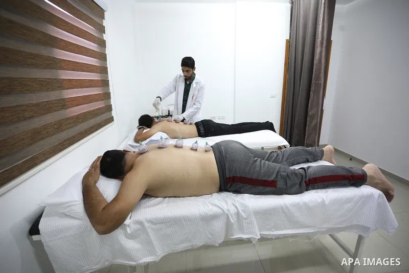 A Palestinian specialist performs Hajima, also knows as "wet cupping therapy", on a patient in Khan Younis in the southern of Gaza strip on September 26, 2021. Hijama is considered a traditional medical treatment in Isla...