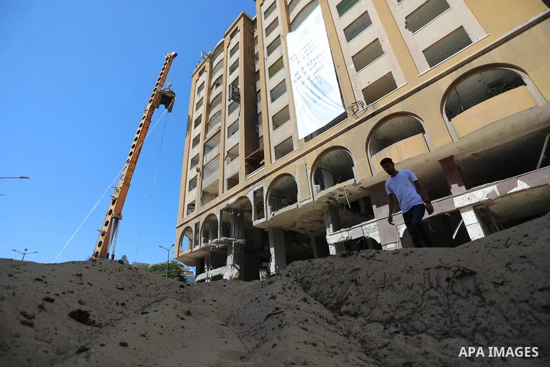 Palestinian workers use a bulldozer to remove the rubbles of al-Jawhara tower which was hit by Israeli strikes during the recent 11-day conflict between Israel and Hamas on May, in Gaza city on September 26, 2021. The to...