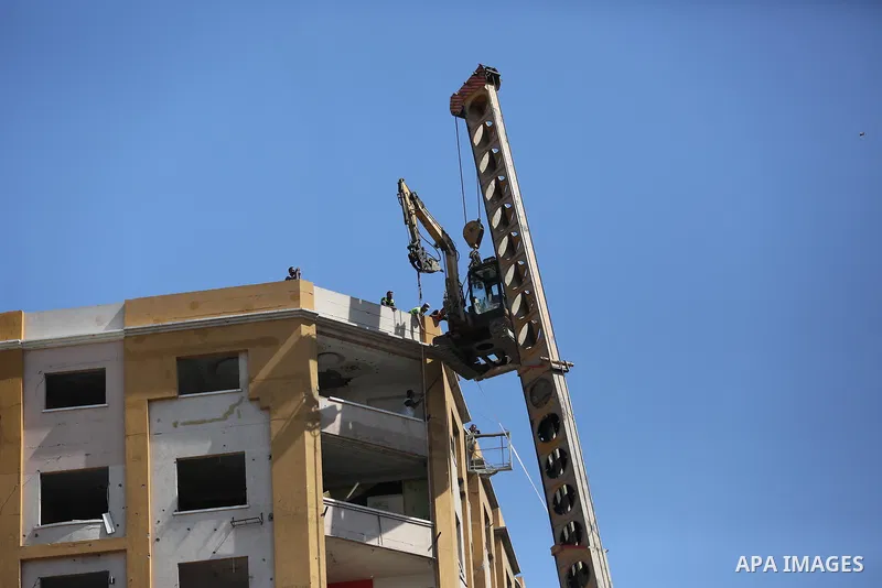 Palestinian workers use a bulldozer to remove the rubbles of al-Jawhara tower which was hit by Israeli strikes during the recent 11-day conflict between Israel and Hamas on May, in Gaza city on September 26, 2021. The to...