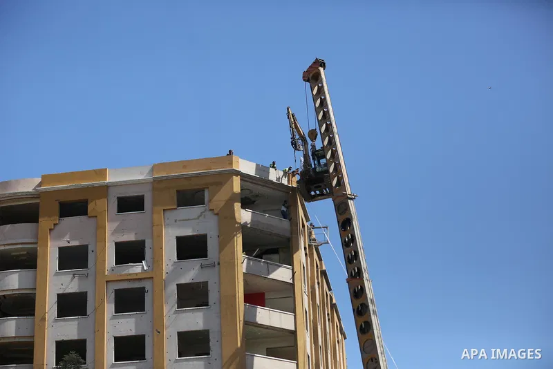 Palestinian workers use a bulldozer to remove the rubbles of al-Jawhara tower which was hit by Israeli strikes during the recent 11-day conflict between Israel and Hamas on May, in Gaza city on September 26, 2021. The to...