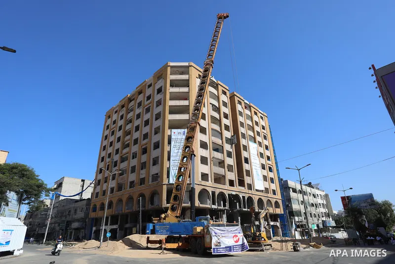 Palestinian workers use a bulldozer to remove the rubbles of al-Jawhara tower which was hit by Israeli strikes during the recent 11-day conflict between Israel and Hamas on May, in Gaza city on September 26, 2021. The to...