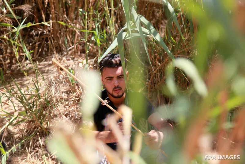 Palestinian youth Mohamed Hamida, 20, makes a musical instrument Yrgoul, in Beit Hanoun in the northern Gaza Strip, on September 27, 2021. The yrgoul instrument is an ancient Palestinian folk instrument, also known as th...