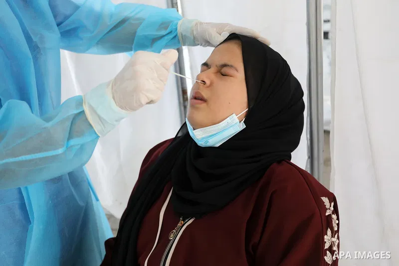 A Palestinian health worker collects a swab sample from a person for Covid-19 test, at a temporary vaccination centre set up, in Deir Al Balah in the center of Gaza strip, in Deir al-Balah in the center of Gaza Strip on...