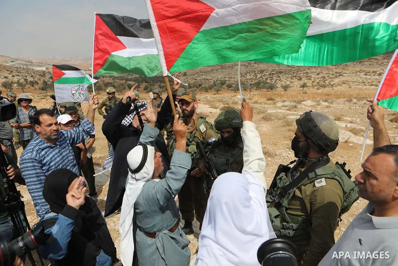 Palestinian demonstrators and Israeli activists, take part in a demonstration against Israeli land confiscation and the cutting of water supply for Palestinians villages, in the southern area of the West bank town of Heb...