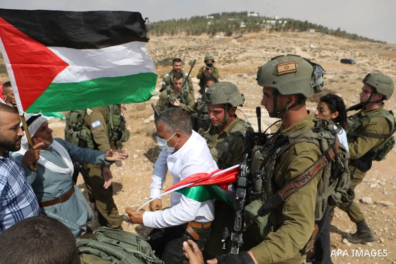 Palestinian demonstrators and Israeli activists, take part in a demonstration against Israeli land confiscation and the cutting of water supply for Palestinians villages, in the southern area of the West bank town of Heb...