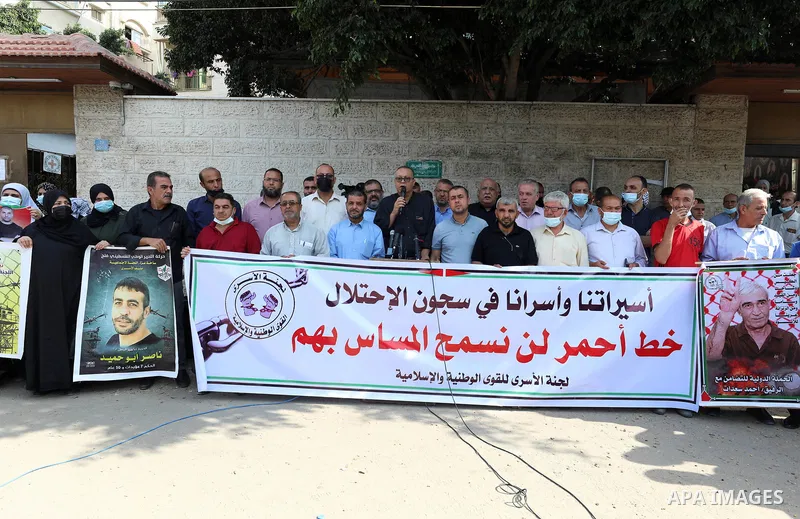 Palestinians take part in a protest to show solidarity with prisoners, in Israeli Jails in front of Red Cross headquarters, on October 4, 2021. Hundreds of Palestinian political detainees in Israeli prisons are expected...