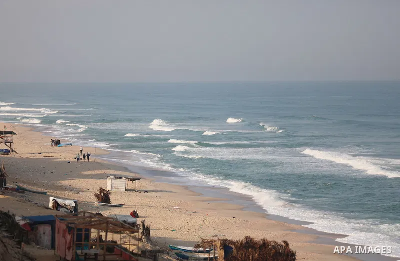 Paestinians walk at on a beach of the Mediterranean Sea, in Gaza city on October 04, 2021. Twelve people have died of coronavirus in Palestine in the last 24 hours as 1559 new cases were confirmed, today said Minister of...