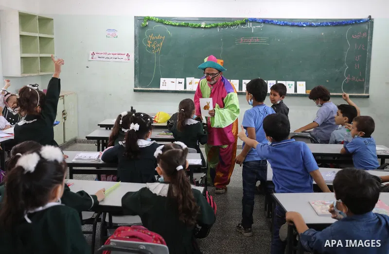 A Palestinian English language teacher, Louay Sheikh Eid, dressed as a clown while teaching school students, in Khan Younis in the southern Gaza strip on October 4, 2021. Sheikh Eid said that he started using this method...