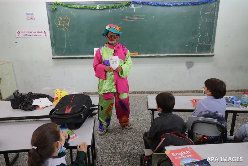 A Palestinian English language teacher, Louay Sheikh Eid, dressed as a clown while teaching school students, in Khan Younis in the southern Gaza strip on October 4, 2021. Sheikh Eid said that he started using this method...