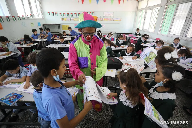A Palestinian English language teacher, Louay Sheikh Eid, dressed as a clown while teaching school students, in Khan Younis in the southern Gaza strip on October 4, 2021. Sheikh Eid said that he started using this method...