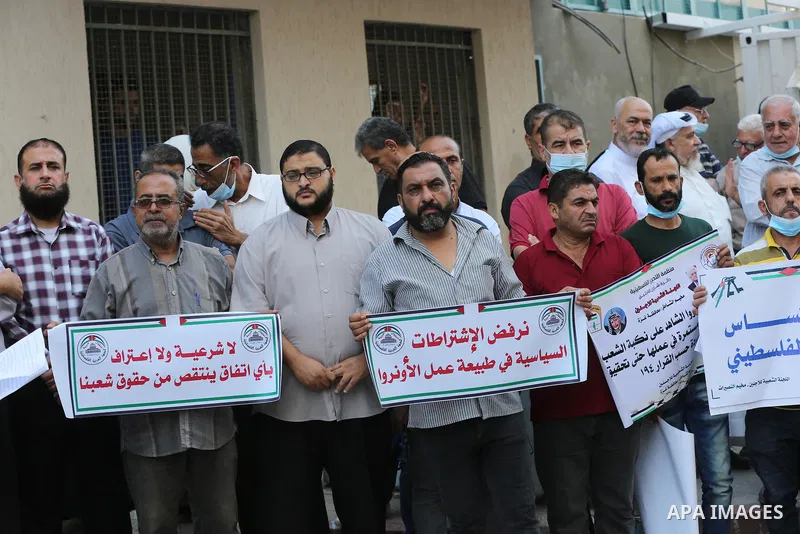 Palestinians take part in a protest against the United States and UNRWA signing a Framework for Cooperation in front of the headquarters United Nations Relief and Works Agency (UNRWA), in Gaza city on October 05, 2021. T...