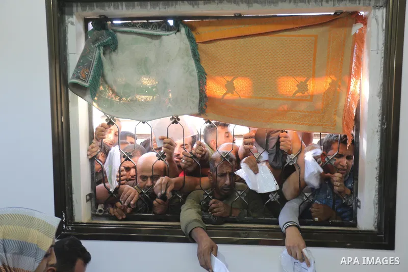 Palestinian citizens gather to apply for work permits in Israel territories in front of the Gaza Chamber of Commerce and Industry ​headquarters to register in order to work inside the Israel territories, in Deir al-Balah...