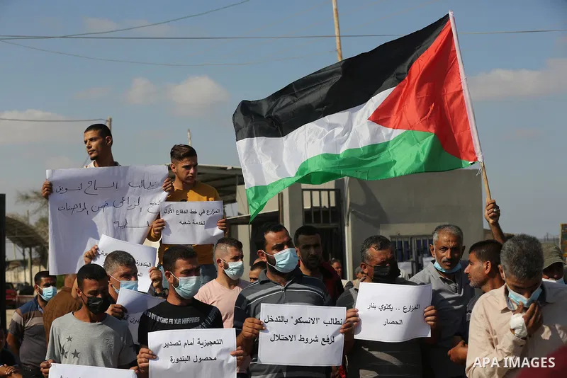 Palestinian farmers and traders take part in a protest against Israeli authorities a new restriction on them in front of the Kerem Shalom crossing in Rafah in the southern Gaza Strip, on October 10, 2021. Israeli authori...