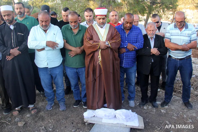Palestinians pray next to the the remains of several graves that were demolished by the Jerusalem municipality and the nature and parks authority at al-Yusufiye cemetery near the Lion's Gate entrance to the Aqsa mosque c...