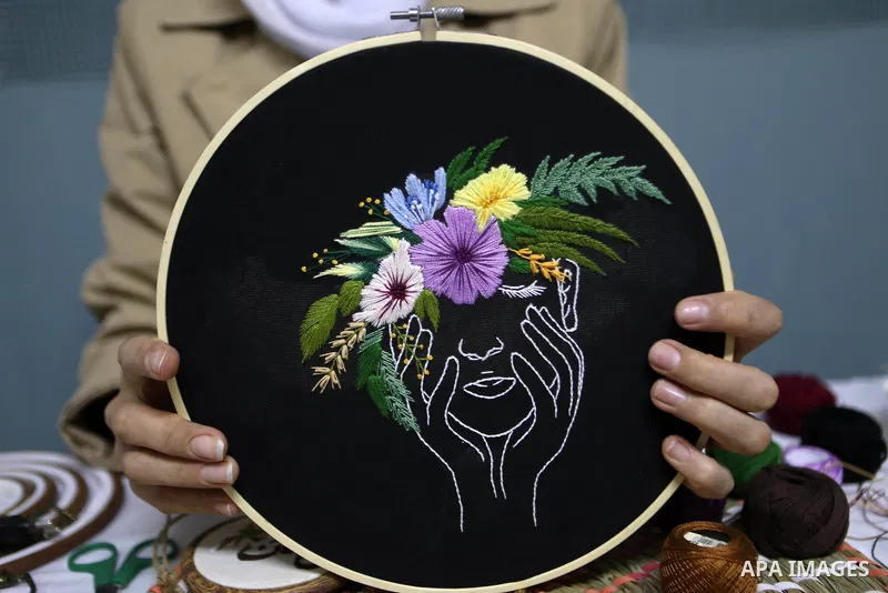 Palestinian artist Hadeel Al-Hassana 24, embroiders on fabric, at her home in the West Bank city of Hebron, on October 14, 2021. Hadeel is a graphic design graduate, and she is the owner of a project in the name of the w...