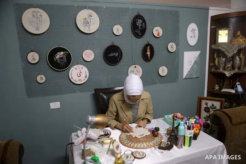 Palestinian artist Hadeel Al-Hassana 24, embroiders on fabric, at her home in the West Bank city of Hebron, on October 14, 2021. Hadeel is a graphic design graduate, and she is the owner of a project in the name of the w...
