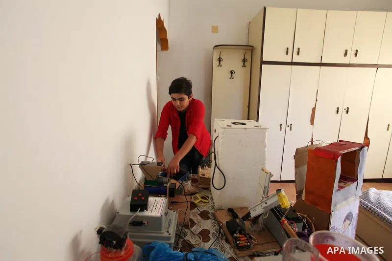 Palestinian inventor Mohammad Al-Hallaq,13, displays his small inventions at his home in Khan Yunis, in the southern Gaza Strip, on October 23, 2021. Al-Hallaq invented the robot for special needs and portable refrigerat...