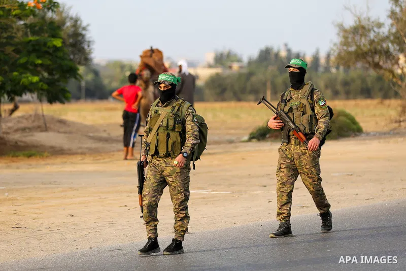 Masked militants from the Izzedine al-Qassam Brigades, a military wing of Hamas, march with their rifles along the main road of Nusseirat refugee camp, central Gaza Strip, in solidarity with Palestinian prisoners on hung...