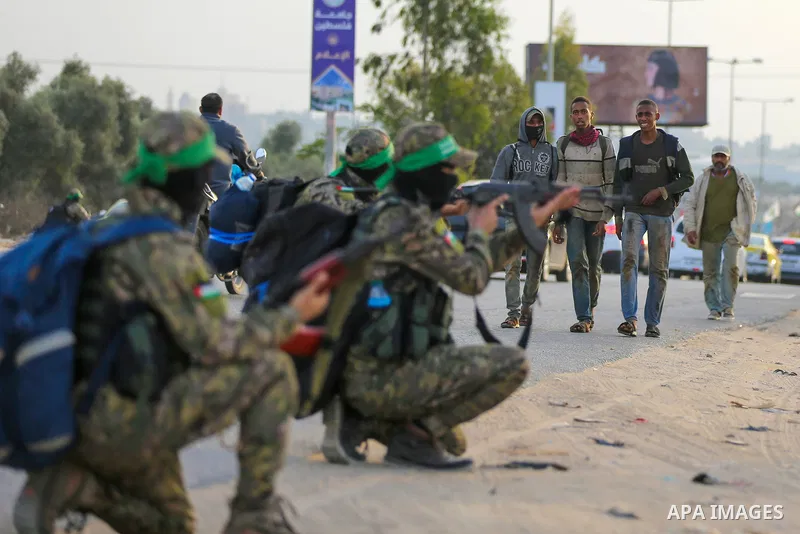 Masked militants from the Izzedine al-Qassam Brigades, a military wing of Hamas, march with their rifles along the main road of Nusseirat refugee camp, central Gaza Strip, in solidarity with Palestinian prisoners on hung...