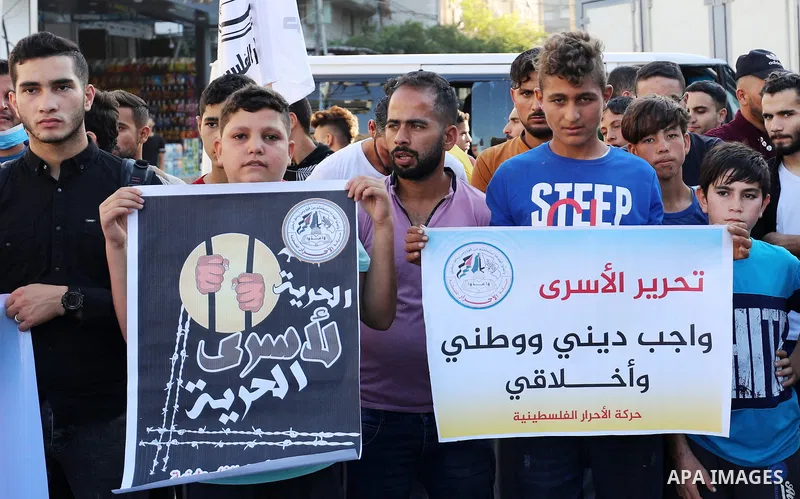 Palestinian supporters of the Al-ahrar Movement, hold placards during a protest in solidarity with prisoners on hunger strike at Israeli Jails, in Jabalia in the northern Gaza strip on November 4, 2021. Photo by Mahmoud...