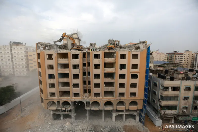 Palestinian workers remove the rubbles of al-Jawhara tower which was hit by Israeli strikes during the recent 11-day conflict between Israel and Hamas on May, in Gaza city on November 14, 2021. Photo by Bashar Taleb