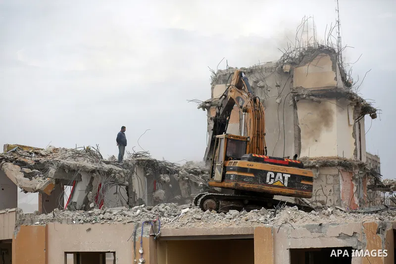Palestinian workers remove the rubbles of al-Jawhara tower which was hit by Israeli strikes during the recent 11-day conflict between Israel and Hamas on May, in Gaza city on November 14, 2021. Photo by Bashar Taleb
