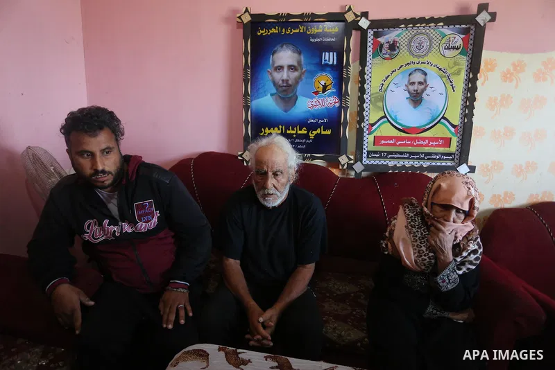 The family of the Palestinian prisoner, Sami Al-Amour sit at their home, in Deir al-Balah camp in the central Gaza Strip, on November 18, 2021. The al-Amour, 39, from the city of Deir al-Balah in the Gaza Strip, died in...