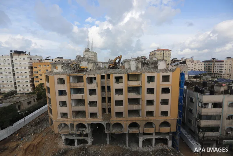 Palestinian workers remove the rubbles of al-Jawhara tower which was hit by Israeli strikes during the recent 11-day conflict between Israel and Hamas on May, in Gaza city on November 21, 2021. Photo by Ashraf Amra
