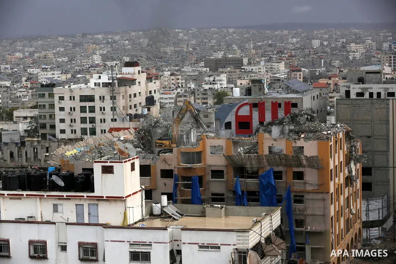 Palestinian workers remove the rubbles of al-Jawhara tower which was hit by Israeli strikes during the recent 11-day conflict between Israel and Hamas on May, in Gaza city on November 21, 2021. Photo by Ashraf Amra